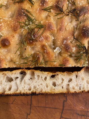 Dettaglio superficie focaccia barese con pomodorini, origano e olio EVO